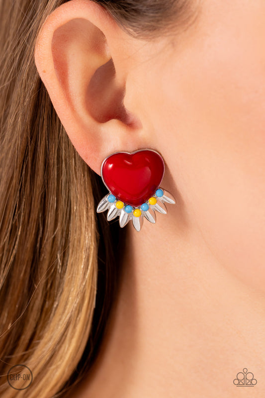 A red heart pressed in a sleek silver frame stands out at the ear. Textured silver leaves flare out from a curved cluster of turquoise and yellow beads that adorn the bottom of the heart display, creating a spring-inspired fringe. Earring attaches to a standard clip-on fitting.   Featured inside The Preview at Made for More! Sold as one pair of clip-on earrings.  Clip On Earring New Kit
