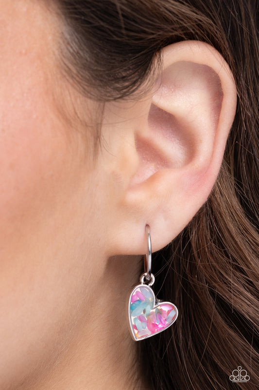 A small, skinny, silver hoop curves around the ear in a timeless fashion with a silver ball affixed to the end of the hoop, reminiscent of a barbell fitting. A silver heart frame, encased with haphazardly patterned pink and turquoise flecks of shell, collides into a kaleidoscope of color for a colorful, shimmery statement. Earring attaches to a standard post fitting. Hoop measures approximately 1/2" in diameter.  Sold as one pair of hoop earrings.