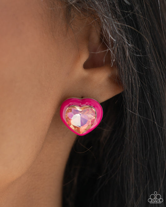 <p>Pressed in a border of Pink Peacock paint, an oversized UV shimmery heart gem glimmers from the ear, resulting in a romantic-inspired display. Earring attaches to a standard post fitting.</p> <p><i> Sold as one pair of post earrings.</i></p>