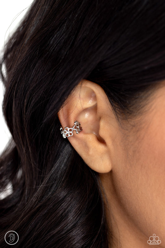 Airy, whimsical silver flowers with silver stud centers curl around the ear for a floral-forward statement. Features a smooth surface for sliding ability to desired position on the ear. Due to its structure, adjusting capability is limited.  Sold as one pair of cuff earrings.   Ear Cuff