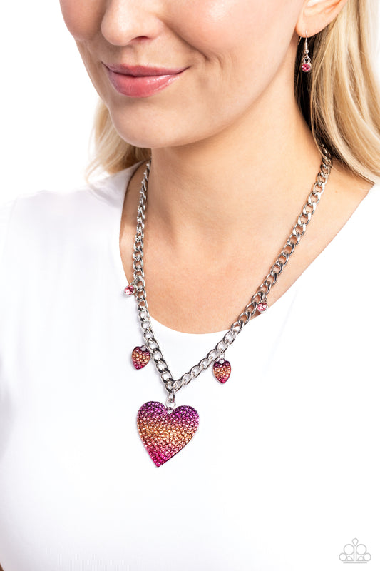 Featuring an ombré effect, dainty silver hearts encrusted with a blinding display of purple to orange to pink rhinestones and solitaire pink gems connect along a classic silver curb chain. An oversized silver heart pendant featuring the same ombré rhinestones cascades from the bottom of the display for a romantically refined finish. Features an adjustable clasp closure.  Sold as one individual necklace. Includes one pair of matching earrings.