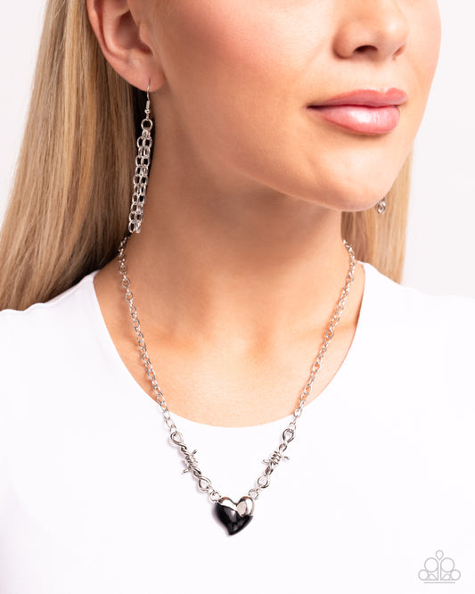 <p>Twists of silver and a half-silver, half-, black-painted heart connect to a classic silver chain around the collar for a trendy statement. Features an adjustable clasp closure.</p> <p><i> Sold as one individual necklace. Includes one pair of matching earrings.</i></p>